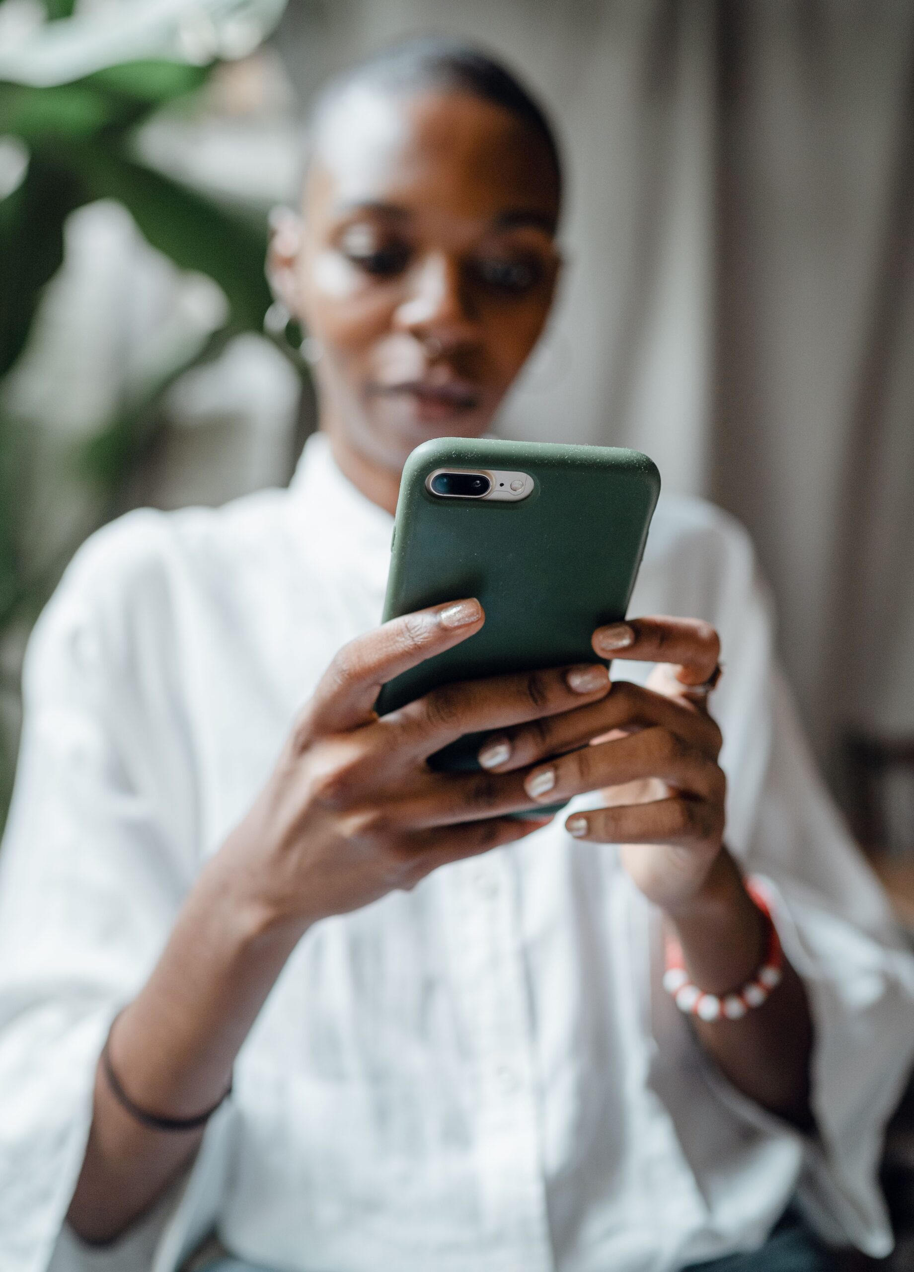 Woman holding a phone in her hand - estradiol patch shortage
